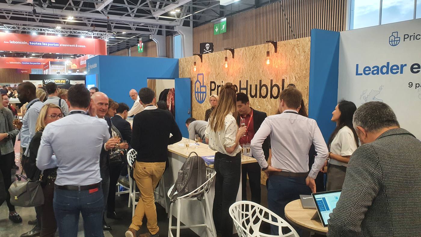 Visitors in conversation at the PriceHubble booth at RENT Paris