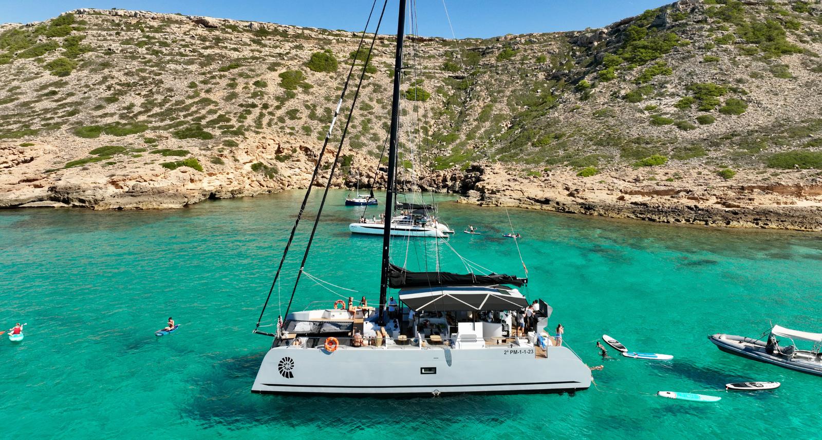 Catamaran anchored in a turquoise cove in Mallorca during a team incentive trip